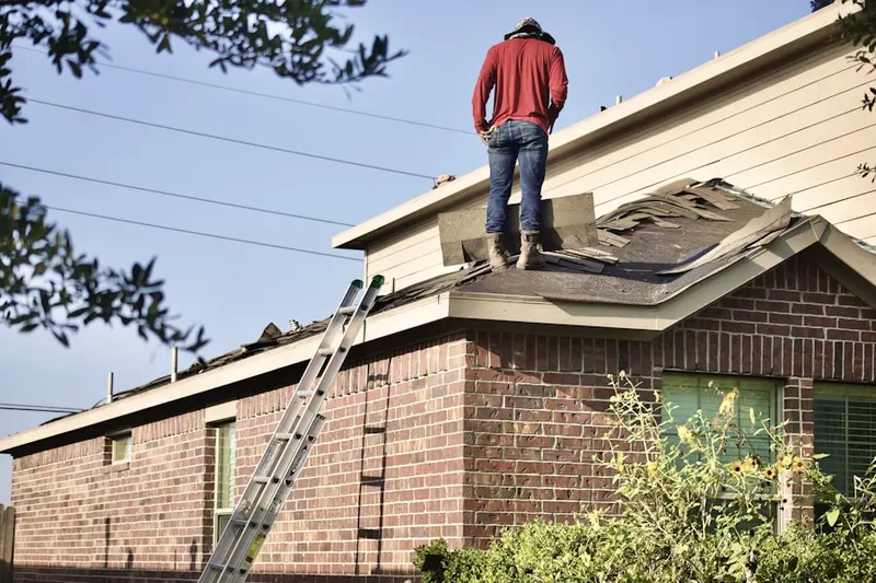 Professional roofer working on a residential roof in Marlyn Manor